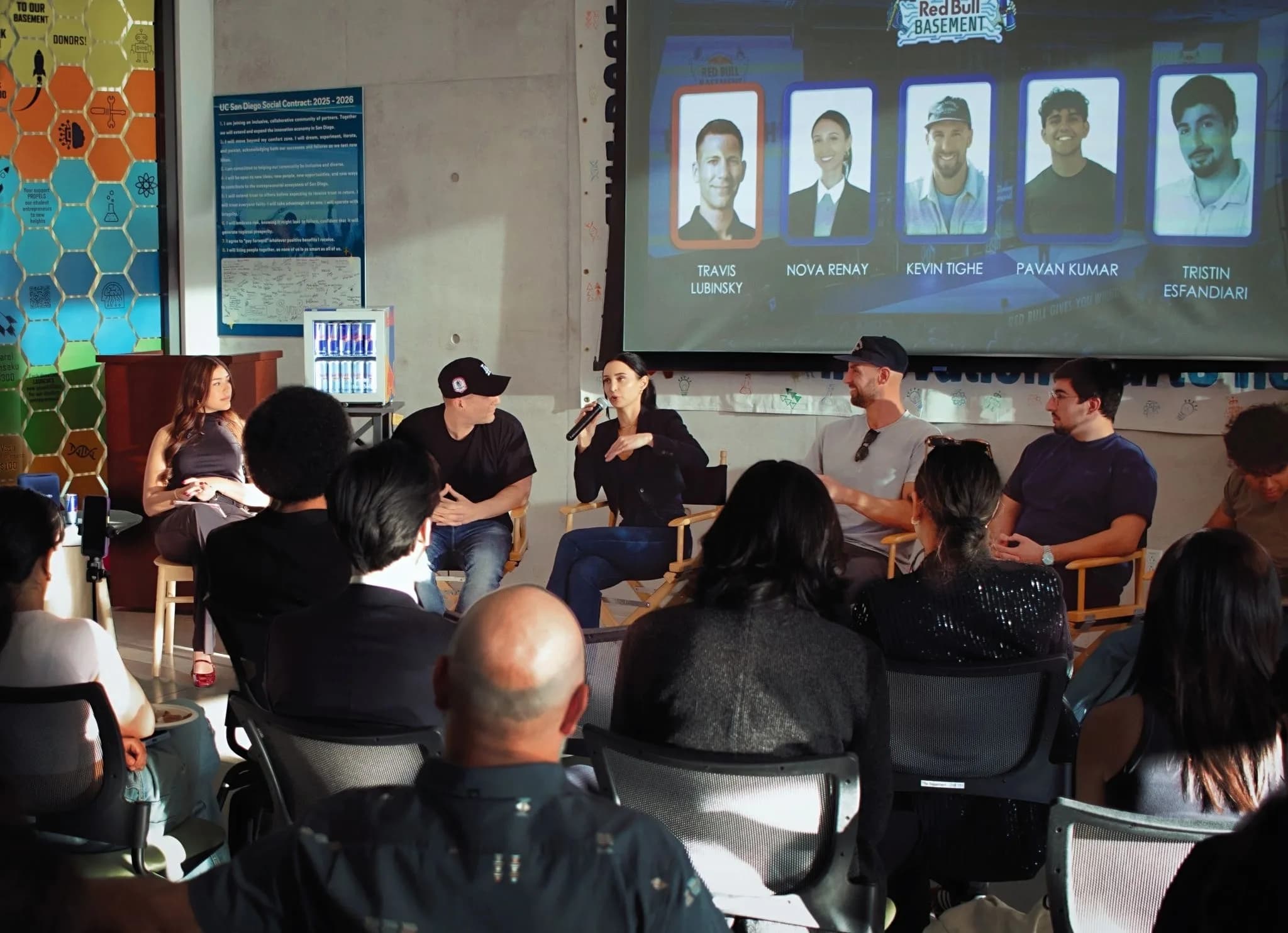 Five panelists in director's chairs under a Red Bull Basement screen showing their headshots, audience seated in the foreground